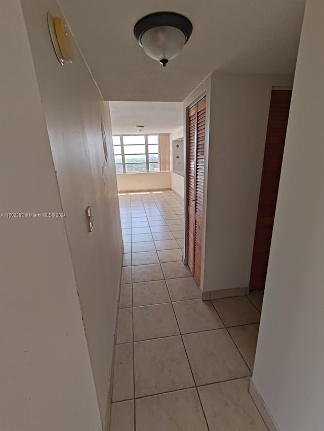 hall with light tile patterned floors