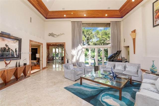 interior space with a towering ceiling, ornamental molding, a tray ceiling, and french doors