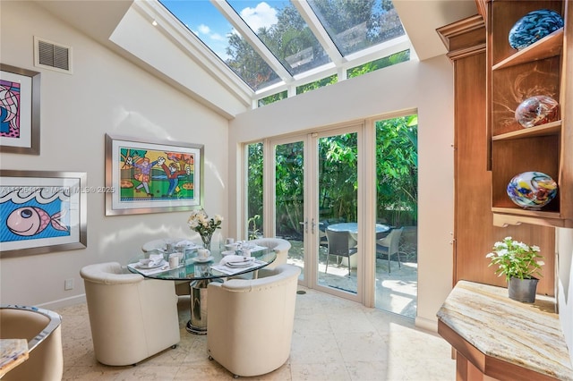 dining space featuring high vaulted ceiling, french doors, and a skylight