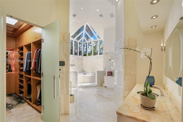 bathroom with separate shower and tub, a towering ceiling, vanity, and tile walls