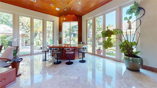 sunroom / solarium featuring wood ceiling, french doors, vaulted ceiling, and a healthy amount of sunlight