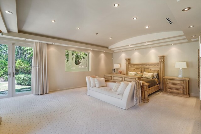 bedroom with light carpet, a tray ceiling, and ceiling fan