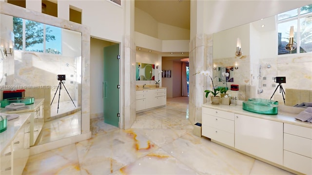 bathroom with a high ceiling, tile walls, and vanity