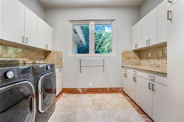 laundry room featuring cabinets and washing machine and clothes dryer