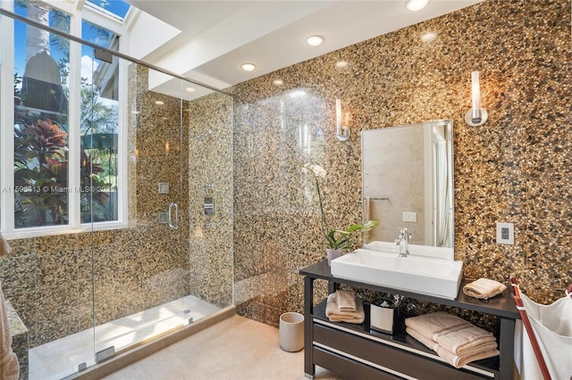 bathroom with sink, a skylight, and an enclosed shower