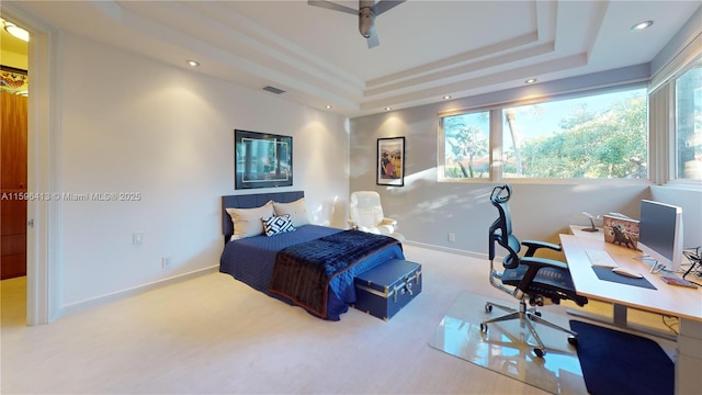 bedroom featuring a raised ceiling, carpet, and ceiling fan