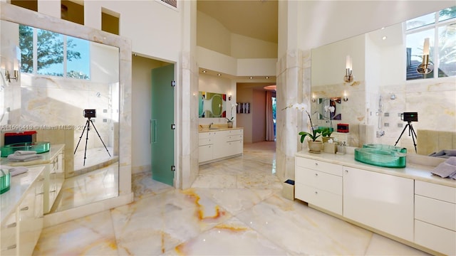 bathroom with vanity and high vaulted ceiling