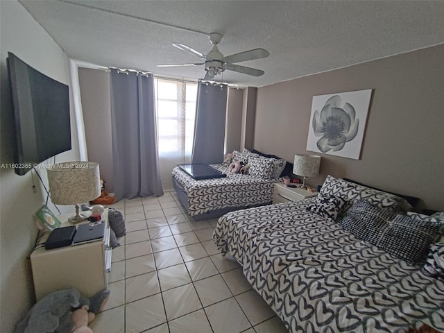 tiled bedroom with ceiling fan and a textured ceiling