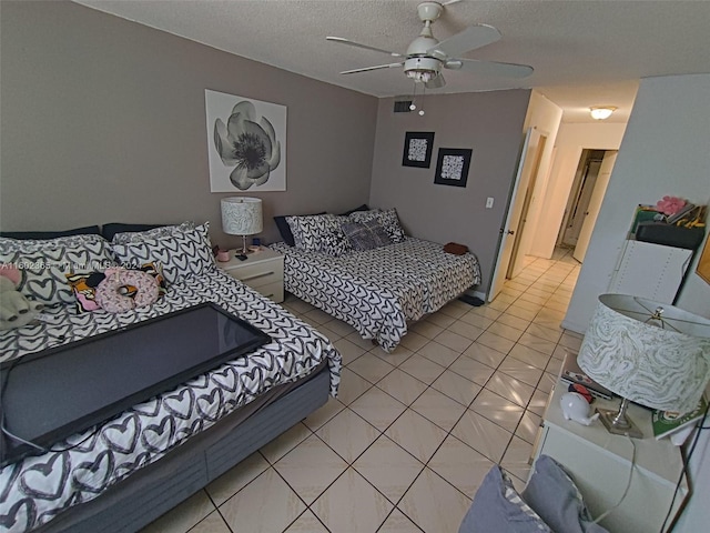 bedroom with ceiling fan, light tile patterned flooring, and a textured ceiling