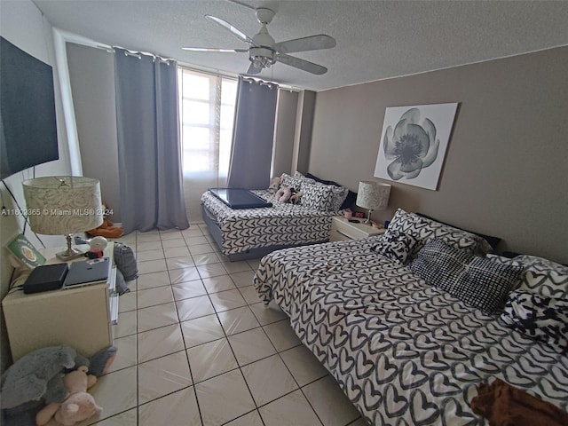 tiled bedroom with ceiling fan and a textured ceiling