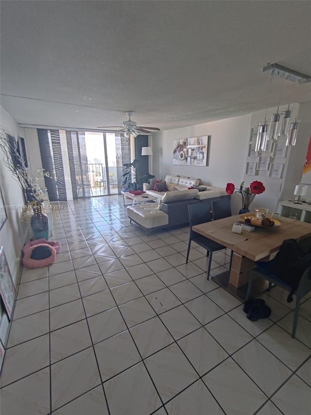 living room with ceiling fan, light tile patterned floors, and a wall of windows