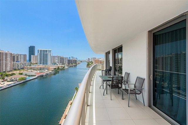 balcony featuring a water view and a city view