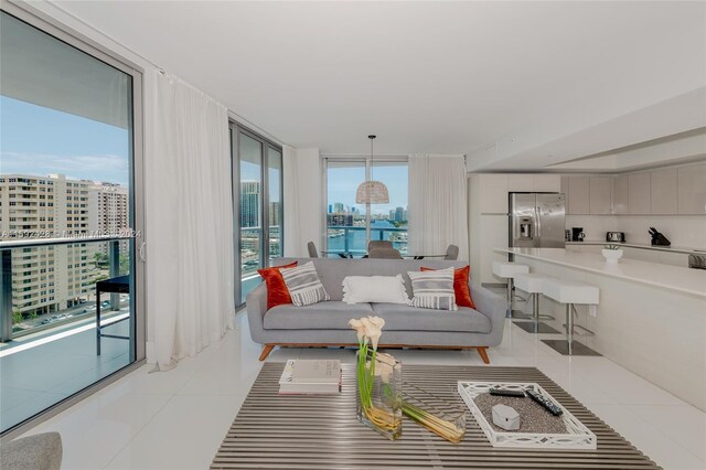 living area featuring light tile patterned floors, a view of city, and floor to ceiling windows