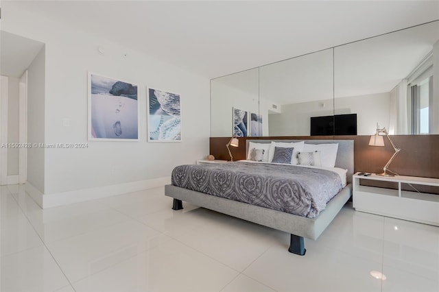 bedroom featuring tile patterned flooring and baseboards