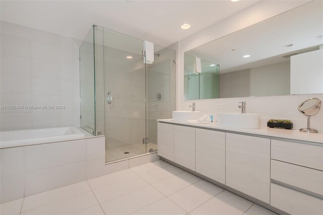 bathroom featuring tile patterned flooring, a sink, and a shower stall