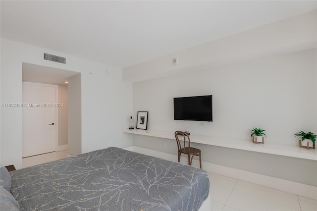 tiled bedroom featuring baseboards, visible vents, and built in desk