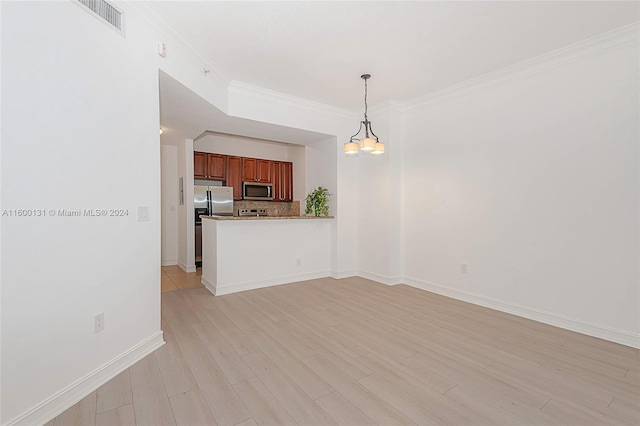 unfurnished living room featuring light hardwood / wood-style flooring, ornamental molding, and a chandelier