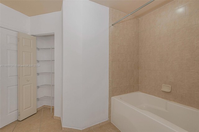 bathroom featuring tiled shower / bath combo and tile patterned floors