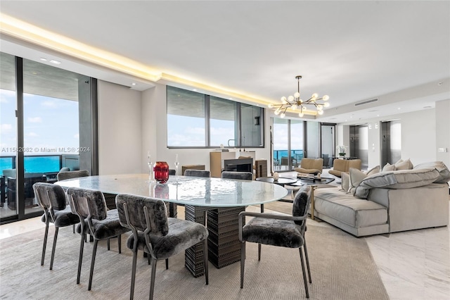 dining area with a notable chandelier, expansive windows, and light tile floors