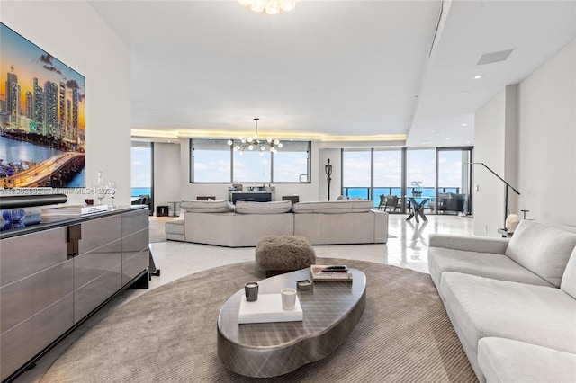 living room with a notable chandelier, floor to ceiling windows, and a water view