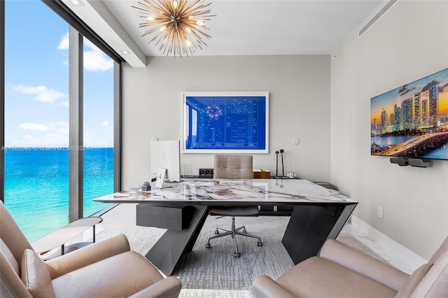 office space featuring a healthy amount of sunlight, expansive windows, a water view, and an inviting chandelier