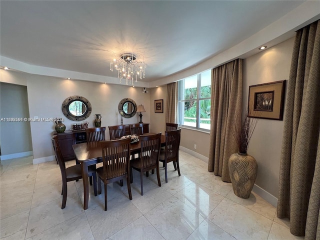 dining space featuring an inviting chandelier, baseboards, and marble finish floor