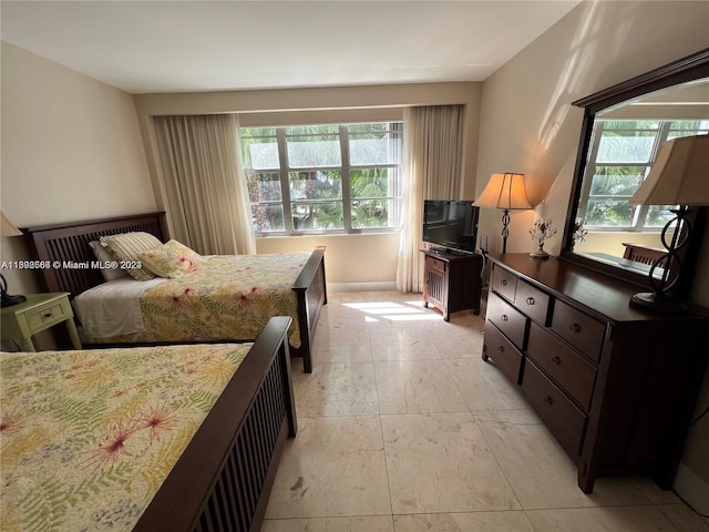 bedroom featuring multiple windows and light tile floors