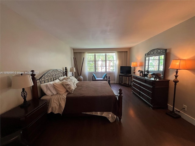 bedroom with baseboards and wood finished floors