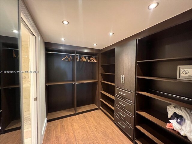 walk in closet with light hardwood / wood-style floors