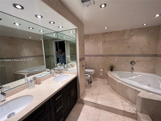 bathroom with double vanity, tile floors, a bidet, tile walls, and toilet