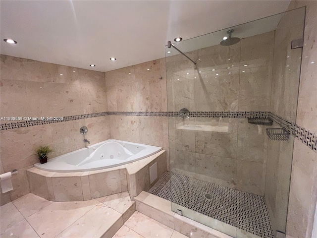 bathroom with a tub with jets, walk in shower, tile walls, and recessed lighting