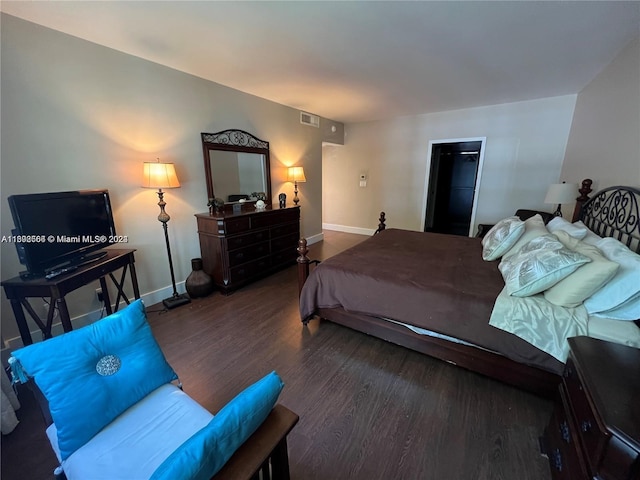 bedroom featuring visible vents, baseboards, and wood finished floors