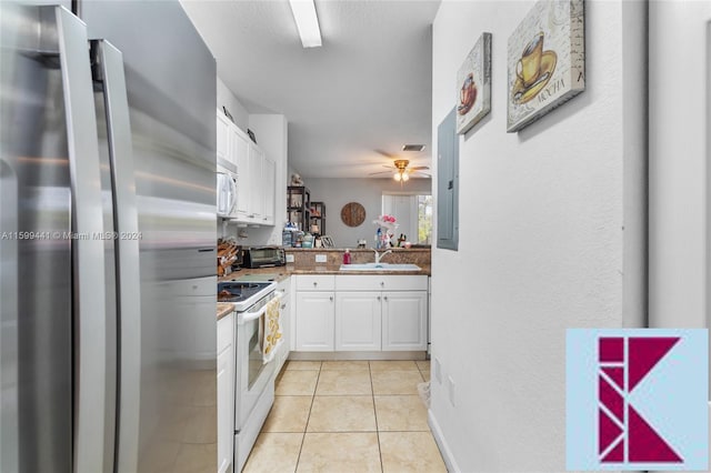 kitchen with white appliances, ceiling fan, sink, light tile patterned floors, and white cabinetry