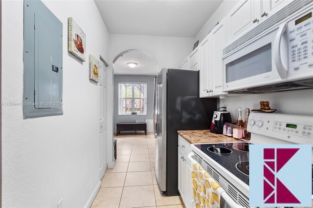 kitchen featuring electric panel, white cabinetry, light tile patterned flooring, and white appliances