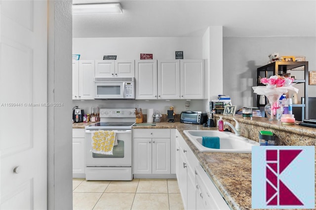 kitchen with white cabinets, light tile patterned flooring, white appliances, and sink