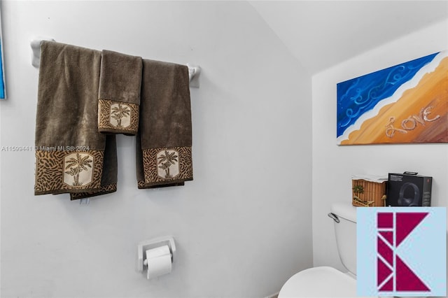 bathroom featuring lofted ceiling and toilet