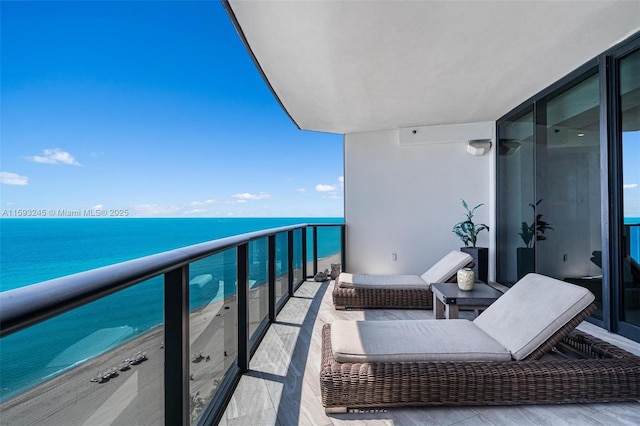 balcony featuring a water view and a view of the beach