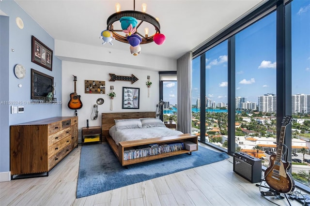 bedroom with light hardwood / wood-style floors and floor to ceiling windows