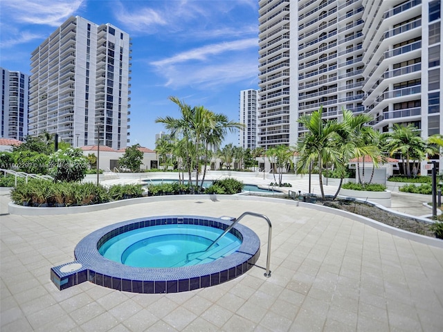 view of swimming pool featuring a community hot tub and a patio