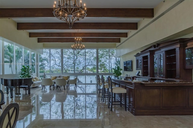 dining area with a healthy amount of sunlight, a chandelier, and beamed ceiling