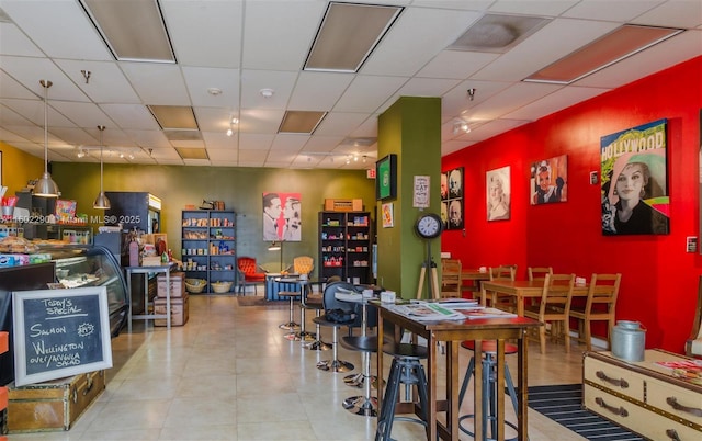 playroom with tile patterned floors and a drop ceiling