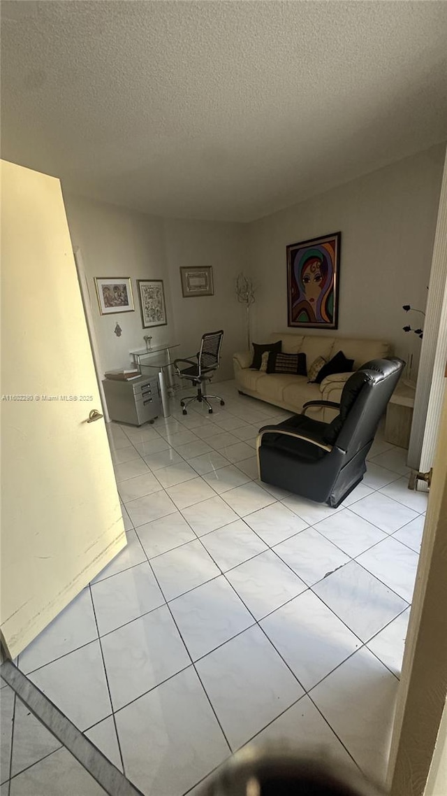 unfurnished living room featuring light tile patterned flooring and a textured ceiling