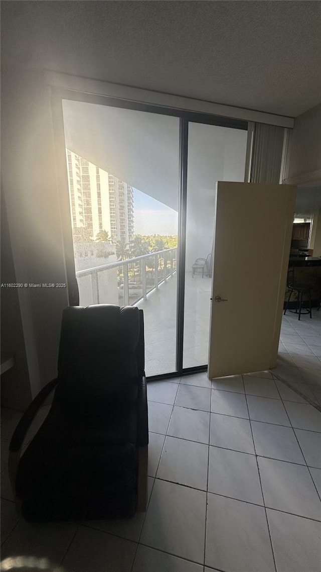 interior space featuring floor to ceiling windows, a textured ceiling, and light tile patterned floors