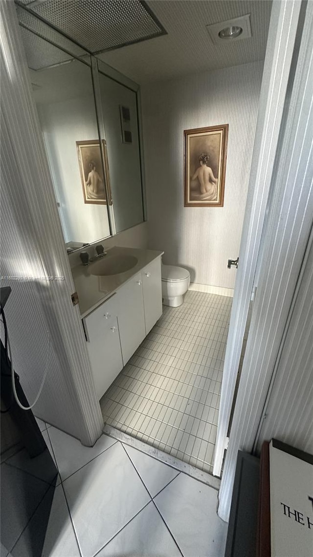 bathroom with toilet, tile patterned floors, and vanity