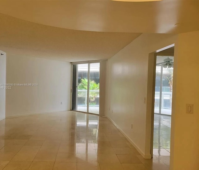 tiled spare room with ceiling fan and a textured ceiling