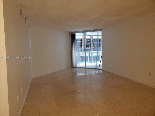 tiled spare room with expansive windows