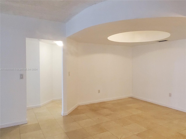 unfurnished room featuring a textured ceiling and light tile patterned floors