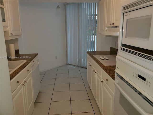 kitchen with light tile patterned floors, white appliances, and white cabinets