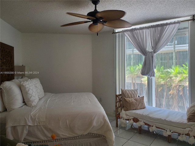 tiled bedroom featuring ceiling fan and a textured ceiling