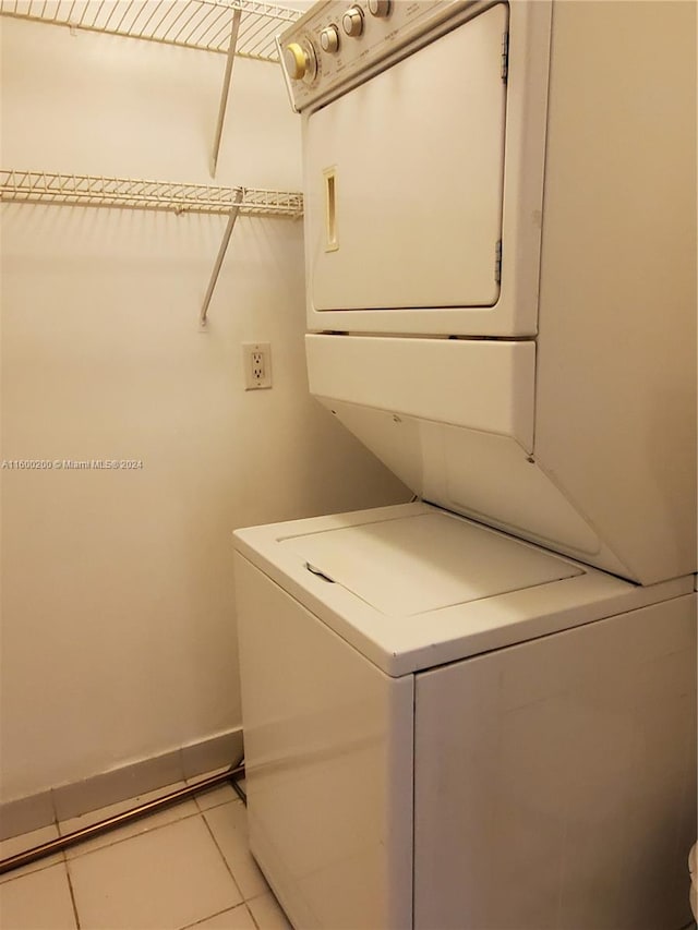 laundry room with stacked washer and dryer and light tile patterned floors